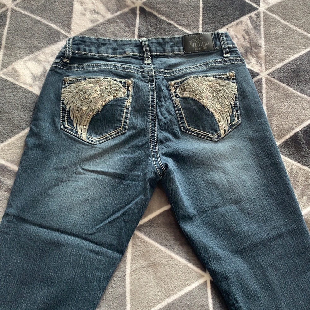 Blue capris with angel wings on the butt pockets